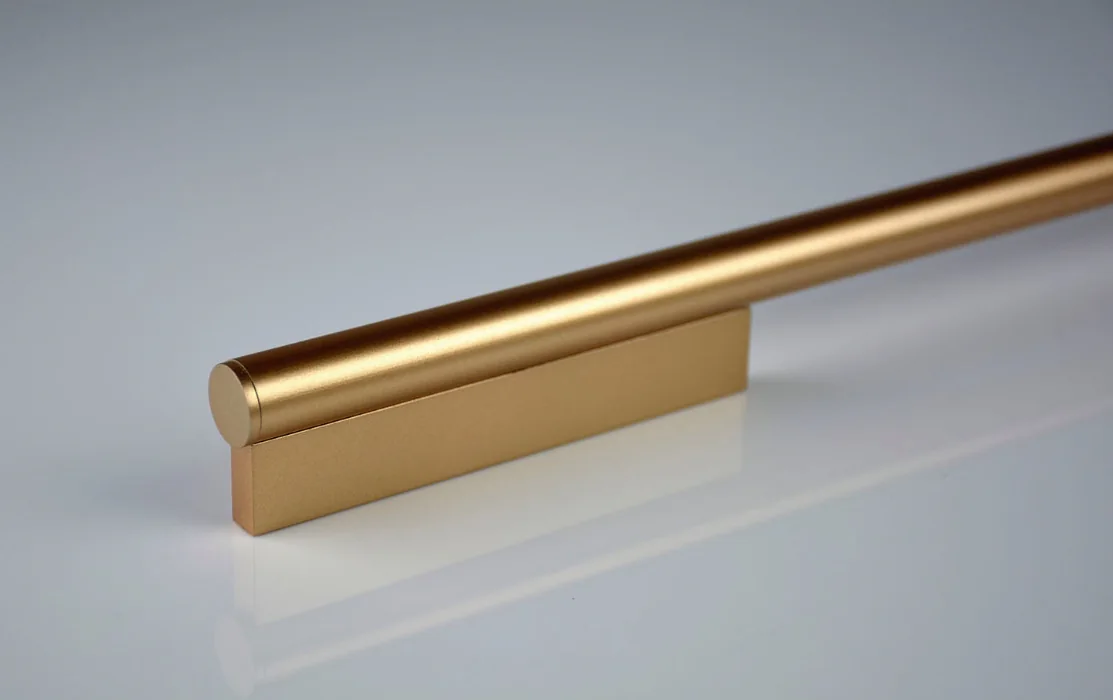 Detalhe de puxador alça dourado aplicado em móvel planejado